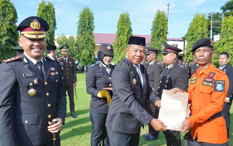 PENGHARGAAN. Bupati Bulukumba Andi Muchtar Ali Yusuf menyerahkan penghargaan kepada salah satu anggota TRC dari BPBD Kabupaten Bulukumba Muhammad Yusuf di sela-sela menghadiri upacara peringatan Hari Bhayangkara ke-79 di halaman Mapolres Bulukumba, Selasa (1/7/2025). foto: istimewa