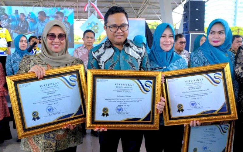 PENGHARGAAN. Bupati dan Wakil Bupati Gowa Sitti Husniah Talenrang-Darmawangsyah Muin (Hati Damai) menerima penghargaan dari Menteri Kependudukan dan Pembangunan Keluarga/BKKBN Wihaji pada Peringatan Hari Keluarga Nasional (Harganas) Ke-32 Tingkat Provinsi Susel di Lapangan Karebosi Makassar, Minggu (27/7/2025). foto: istimewa 