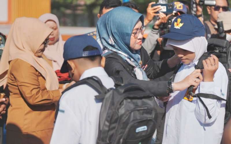 PENYERAHAN. Bupati Gowa, Sitti Husniah Talenrang, secara simbolis menyerahkan seragam sekolah gratis bagi siswa baru SD dan SMP se-Kabupaten Gowa yang mulai dilaunching di Taman Sultan Hasanuddin, Gowa, Senin (7/7/2025). foto: istimewa
