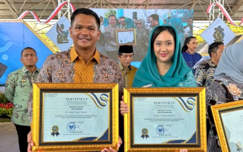 PENGHARGAAN. Bupati Bantaeng M Fathul Fauzy Nurdin bersama Ketua TP PKK Bantaeng Gunya Paramasukhaputri menerima penghargaan dari Menteri Kependudukan dan Pembangunan Keluarga/Kepala BKKBN Wihaji pada peringatan Harganas ke-32 Tingkat Provinsi Sulsel di Lapangan Karebosi Makassar, Minggu (27/7/2025). foto: istimewa