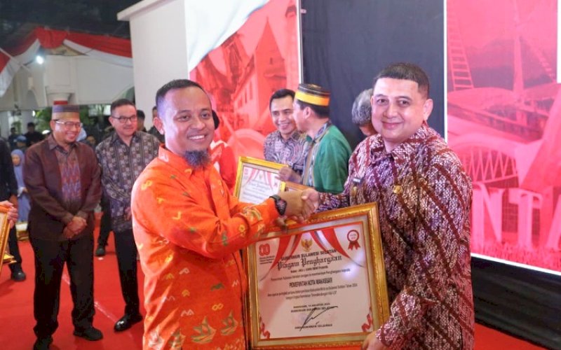 PENGHARGAAN. Gubernur Sulsel Andi Sudirman Sulaiman menyerahkan penghargaan kepada Wali Kota Makassar Munafri Arifuddin pada malam ramah tamah kenegaraan yang digelar di Pelataran Merah Putih, Rumah Jabatan Gubernur Sulsel, Minggu (17/8/2025) malam. foto: istimewa