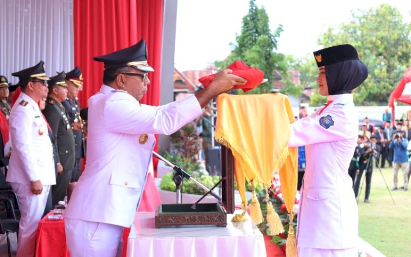 PENYERAHAN. Bupati Bulukumba, Andi Muchtar Ali Yusuf, menyerahkan bendera merah putih kepada amggota Paskibraka untuk dikibarkan pada upacara bendera HUT Kemerdekaan RI Ke-80 di Lapangan Pemuda Bululumba, Minggu (17/8/2025). foto: istimewa