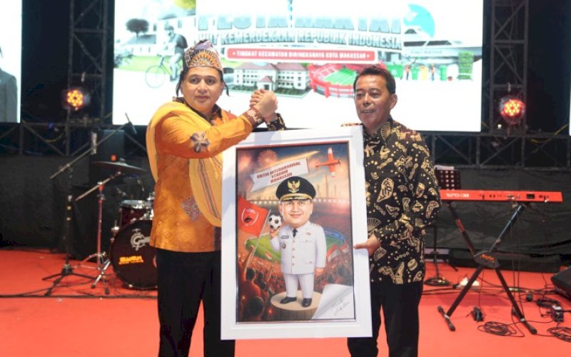 PESTA RAKYAT. Camat Biringkanaya Juliaman menyerahkan cendera mata kepada Wali Kota Makassar Munafri Arifuddin di sela-sela pesta rakyat rangkaian perayaan HUT Kemerdekaan RI ke-80, yang berlangsung di De&rsquo; Festive Kawasan Summarecon Mutiara, Selasa (26/8/2025) malam. foto: istimewa