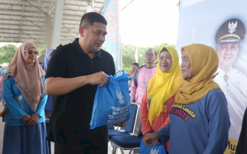 PEDULI. Wali Kota Makassar, Munafri Arifuddin, menyerahkan bingkisan kepada peserta senam massal bersama ribuan lansia dalam acara bertema 'Lansia Sehat, Bahagia, dan Produktif untuk Makassar Mulia' di Lapangan Karebosi Makassar, Jumat (21/11/2025). foto: istimewa