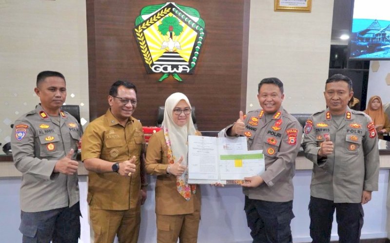 KERJA SAMA. Bupati Gowa Sitti Husniah Talenrang dan Direktur Pembinaan Masyarakat Polda Sulsel Kombes Pol Anang Triarsono memperlihatkan nota kesepakatan kesepakatan usai penandatanganan di Baruga Karaeng Pattingalloang, Kantor Bupati Gowa, Senin (3/11/2025). foto: istimewa