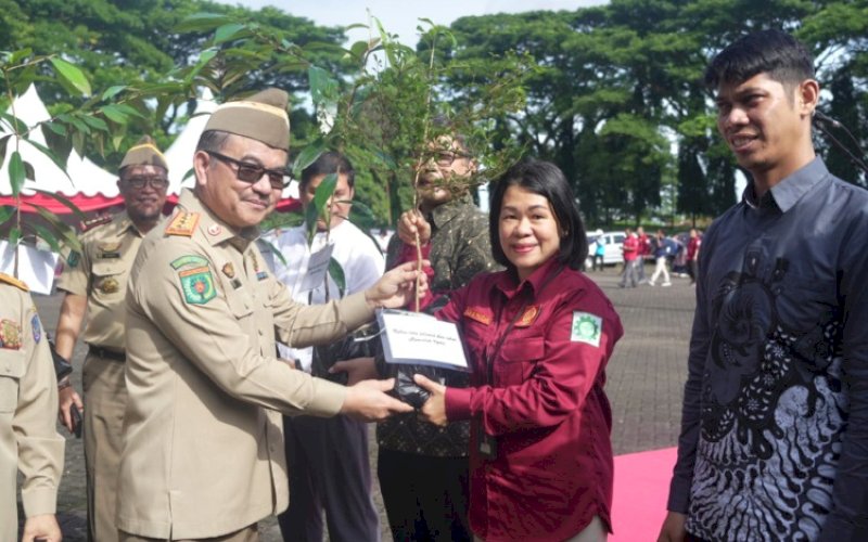 BIBIT POHON. Sekda Sulsel Jufri Rahman menyerahkan bibit pohon kepada Division Head Operasi Pelindo Regional 4 Yusida M Palesang di sela-sela Upacara Peringatan Bulan K3 Nasional 2026 Tingkat Provinsi Sulsel yang berlangsung di Lapangan Upacara Kantor Gubernur Sulsel, Kamis (12/2/2026). foto: istimewa