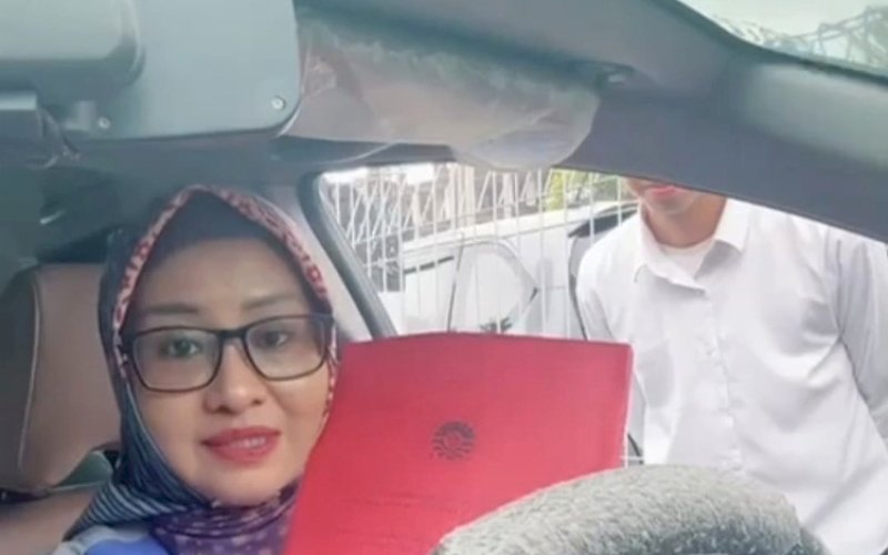 MENGUJI. Qadriathi Dg Bau, saat menguji skripsi mahasiswa di area parkir dari atas mobil. foto: istimewa