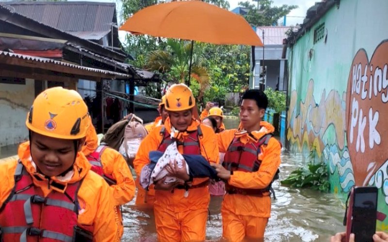 EVAKUASI. TRC BPBD Kota Makassar melakukan evakuasi seorang bayi yang terdampak banjir, Selasa (24/2/2026). foto: istimewa