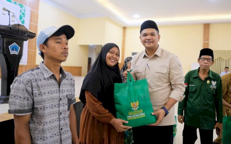 BANTUAN. Bupati Bantaeng, M Fathul Fauzy Nurdin, menyerahkan bantuan paket sembako kepada 670 orang mustahik secara simbolis dalam kegiatan bertajuk Cahaya Zakat Ramadhan Berkah 'Terangi Butta Toa dengan Zakat, Bangkit Bersama dalam Keberkahan' di Gedung Balai Kartini, Kabupaten Bantaeng, Senin (9/3/2026). foto: istimewa