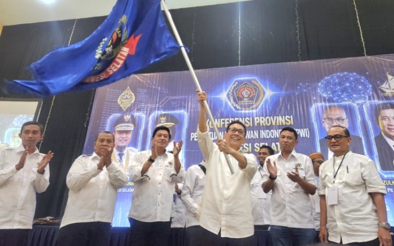 KETUA TERPILIH. Suwardi Thahir mengibarkan bendera PWI usai terpilih sebagai Ketua PWI Sulsel periode 2026-2031 pada Konferprov PWI Sulsel di Graha Pena, Kota Makassar, Selasa (2/6/2026). foto: doelbeckz/pluz.id