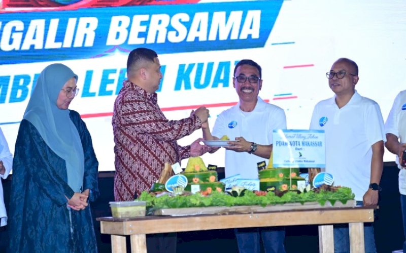 HUT PDAM. Wali Kota Makassar Munafri Arifuddin didampingi Ketua TP PKK Kota Makassar Melinda Aksa menerima potongan tumpeng dari Direktur Utama Perumda Air Minum Kota Makassar Andi Syahrum Makkuradde pada Gathering Pegawai rangkaian puncak peringatan Hari Ulang Tahun (HUT) Perumda Air Minum Kota Makassar ke-102 di Pantai Indah Bosowa Makassar, Sabtu (15/8/2026). foto: istimewa